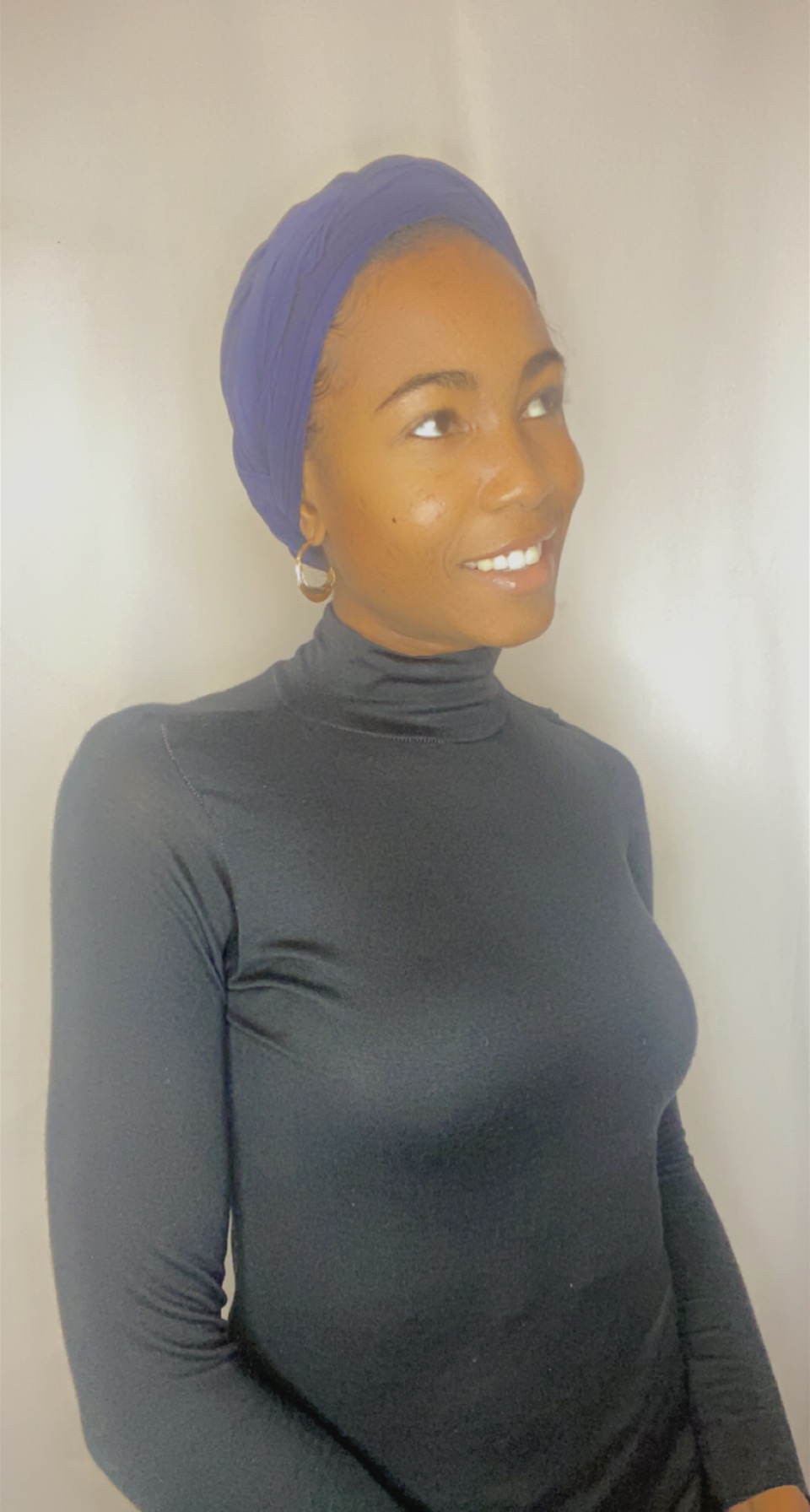 Portrait of a woman smiling in a deep iris Krown headband
