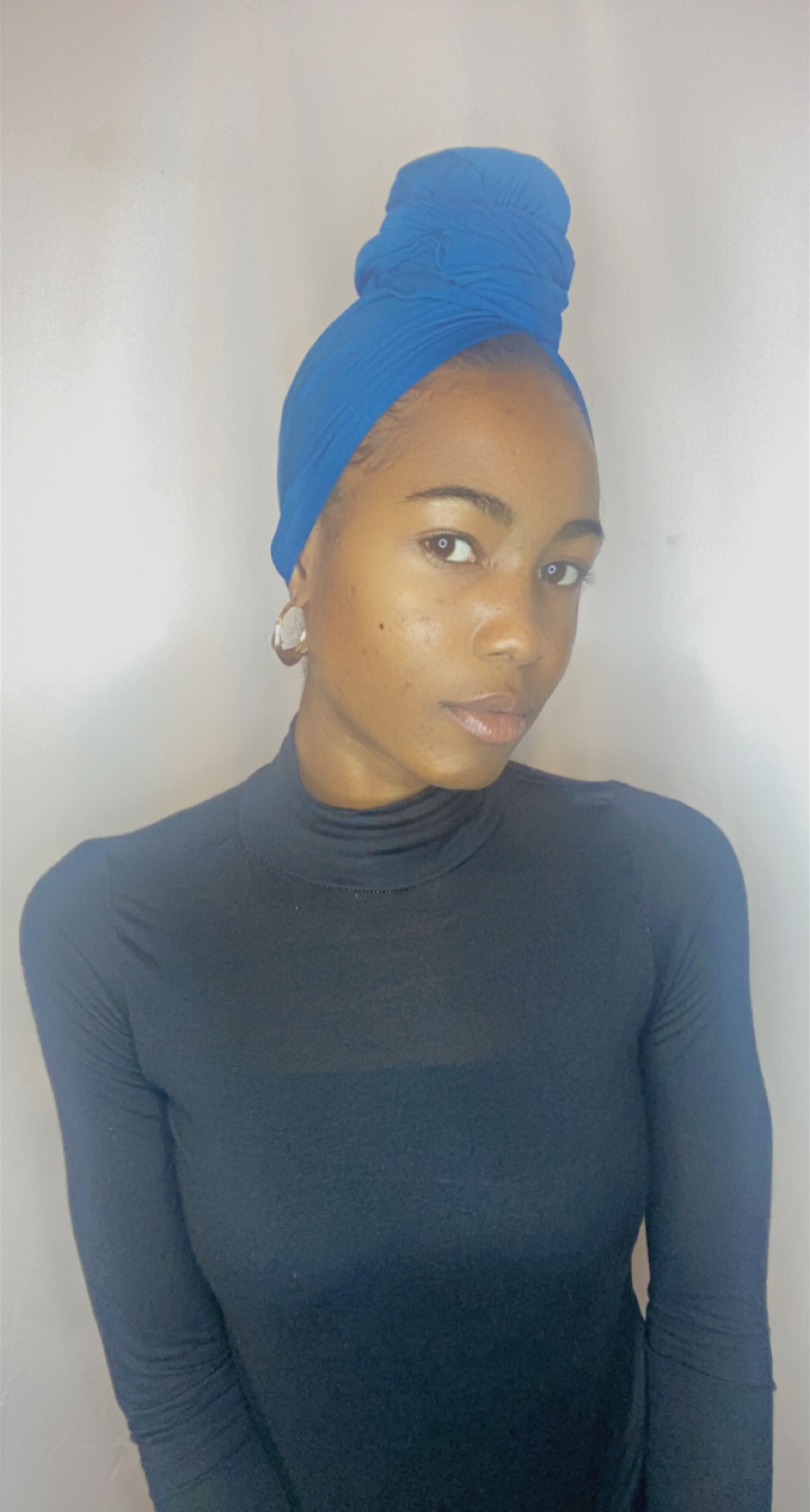 Front portrait of a woman wearing a royal blue Krown styled as a high topknot wrap