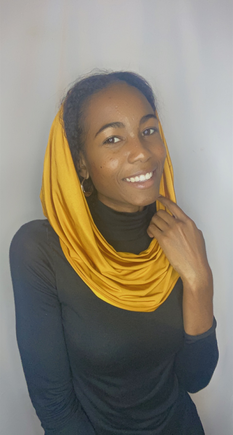 Woman smiling with a saffron yellow Krown styled as a loose snood draped around her neck and head