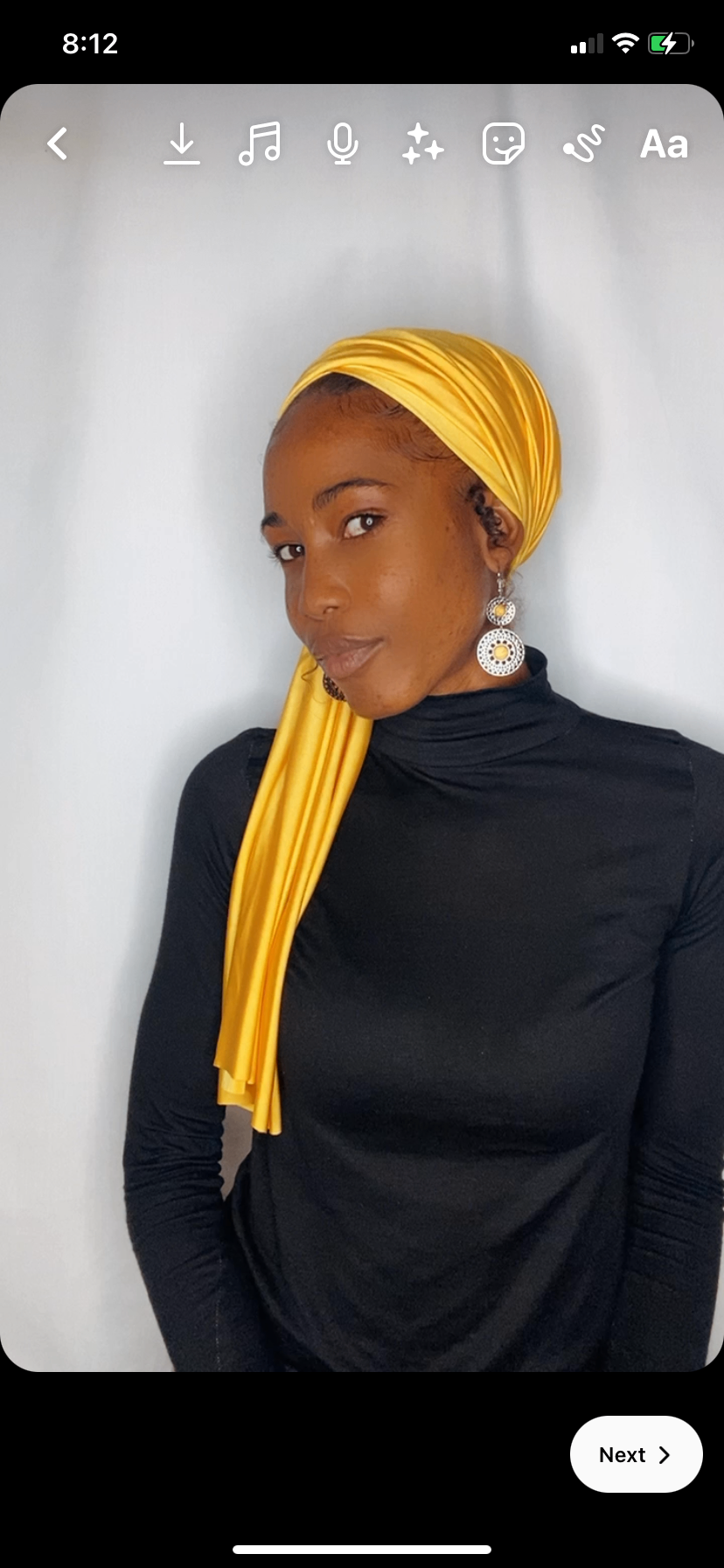 Front view of a saffron yellow Krown wrapped as a wide headband with the tail draped forward